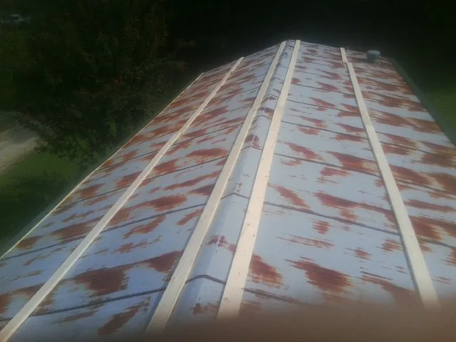 Rusted metal roof panels with new wood purlins before replacement — Storm Damage Roof Repair in Glenham by Roofing Brothers