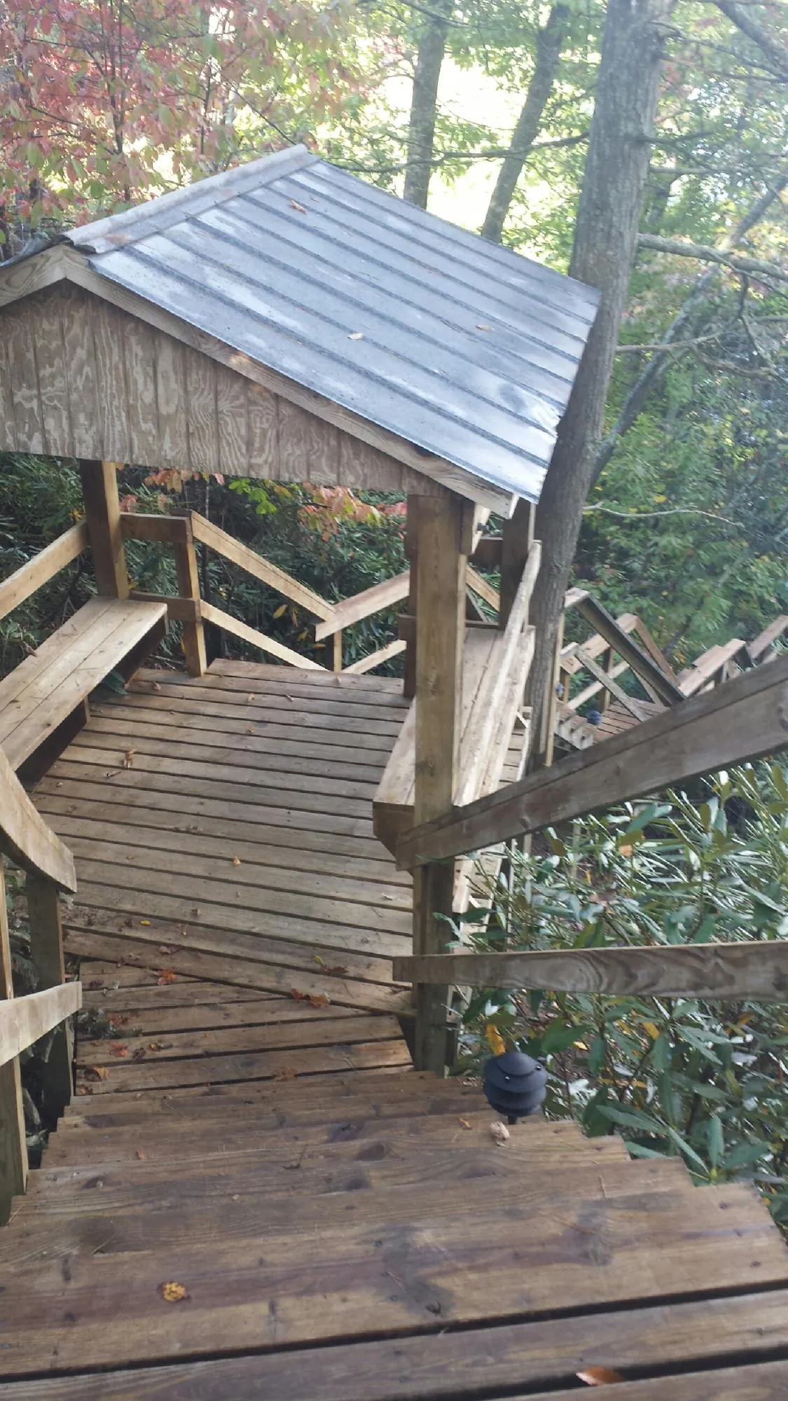 Metal roofed shelter over wooden steps on a wooded walkway — Skylight Repair & Installation work by our crew in Glenham