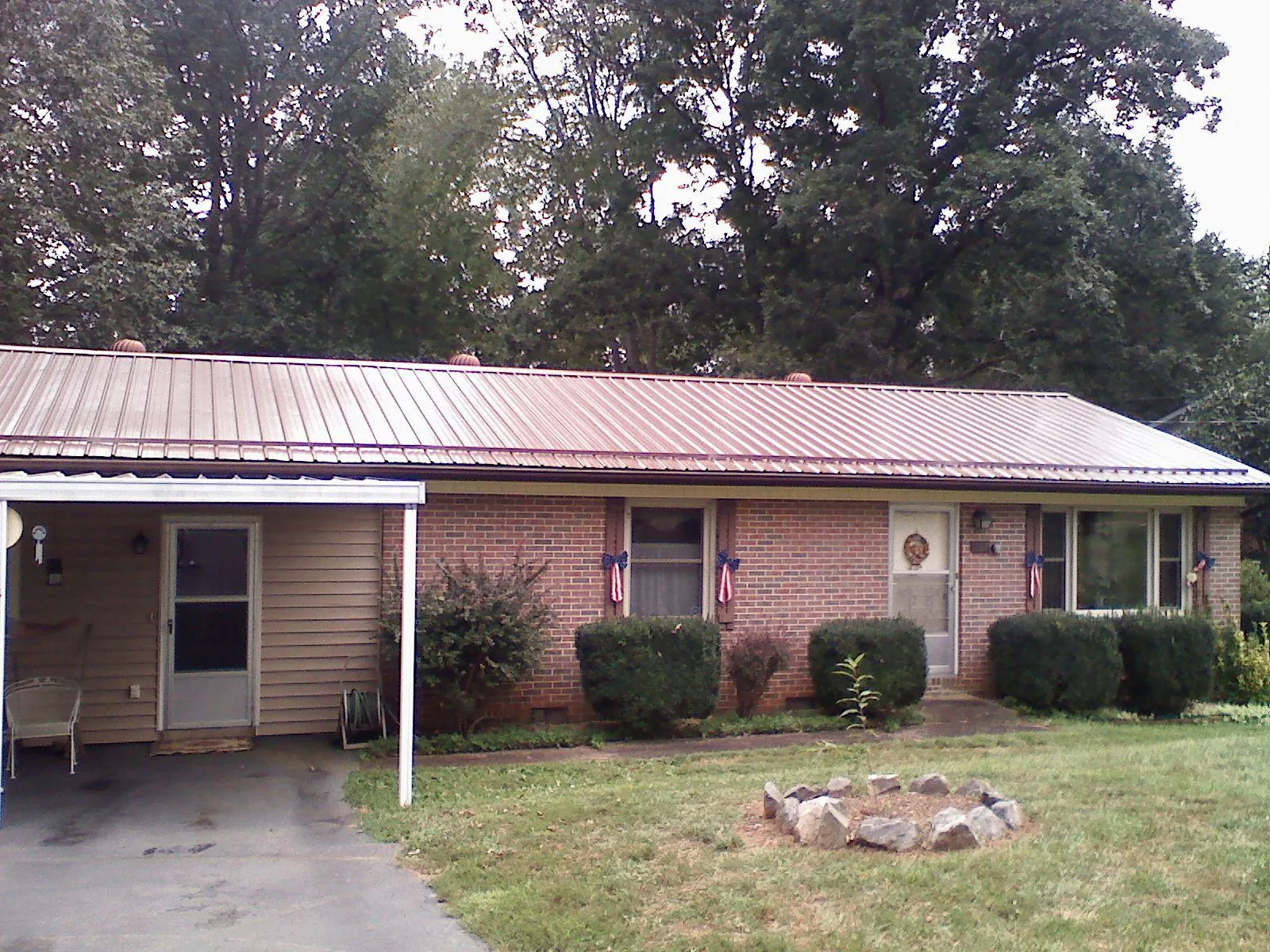 Bronze metal roof and carport on a brick ranch home — Roof Repair work by our crew in Glenham